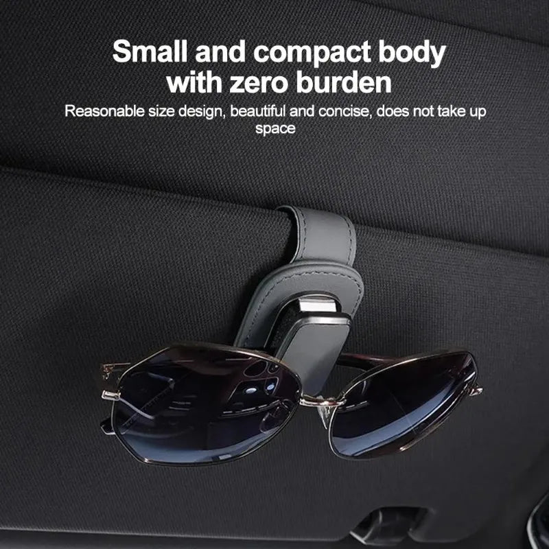 Eine Paar dunkle Sonnenbrille ist an einer PU-Leder-Aufhängeclip für ein Autoschirm befestigt.