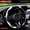 Black steering wheel with white carbon fiber cover and blue Sport logo installed in a car interior.
