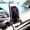 A smartphone displaying the time and date is mounted on a car dashboard using a gravity expanding phone holder mount.
