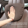 Une main repose sur un coussin de tête de voiture en cuir brun, mettant en évidence la protection du cou et le confort de la 