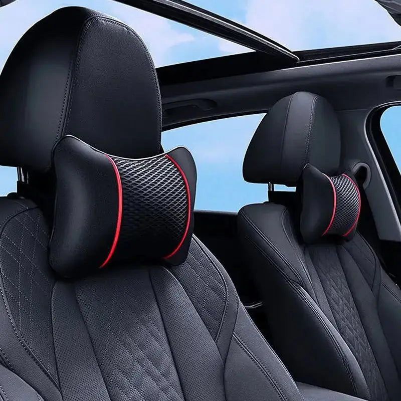 Black car seat headrest neck support cushion with red accents shown inside a vehicle.