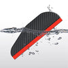 A black carbon fiber rearview mirror rain shield with an orange accent floating in water.