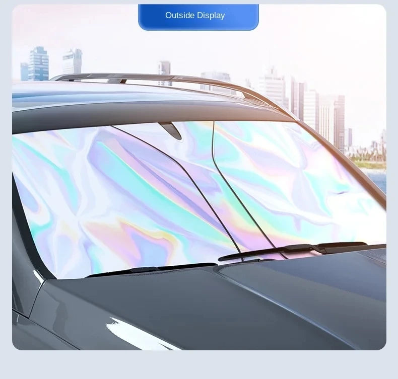 A close-up view of a car's windshield with a reflective, iridescent sunshade installed for protection.