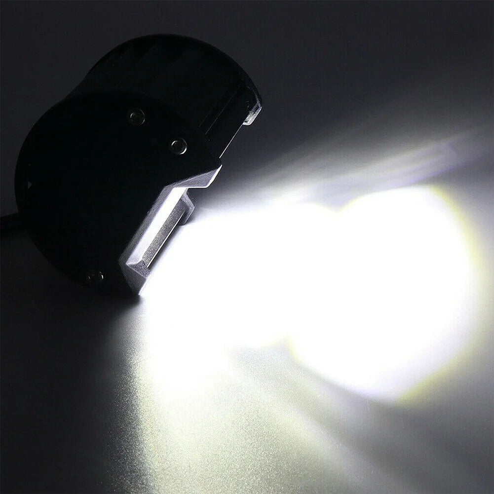 A high-intensity LED off-road flood bar mounted on a black bracket, shining a bright beam.