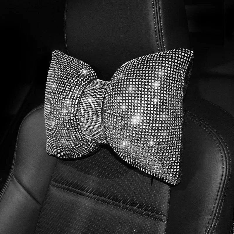 Primer plano de un lazo de pedrería cristalina con forma de almohada para el cuello de un coche sobre una superficie de cuero