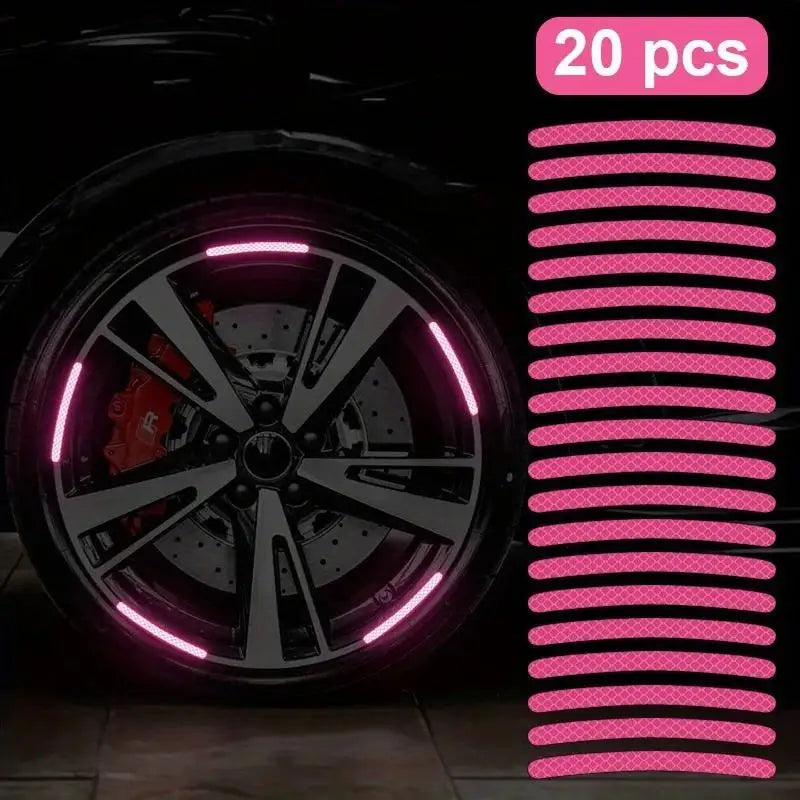 A close-up view of a black car tire and wheel with pink LED reflective decoration.
