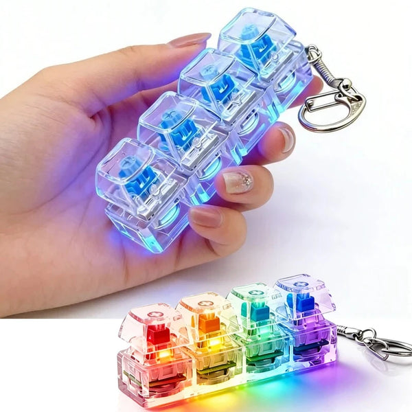 A hand holds a clear plastic keychain featuring illuminated mechanical keyboard keys in various colors.