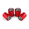 Three shiny red metal tire valve caps with Volkswagen logos displayed on a white background.