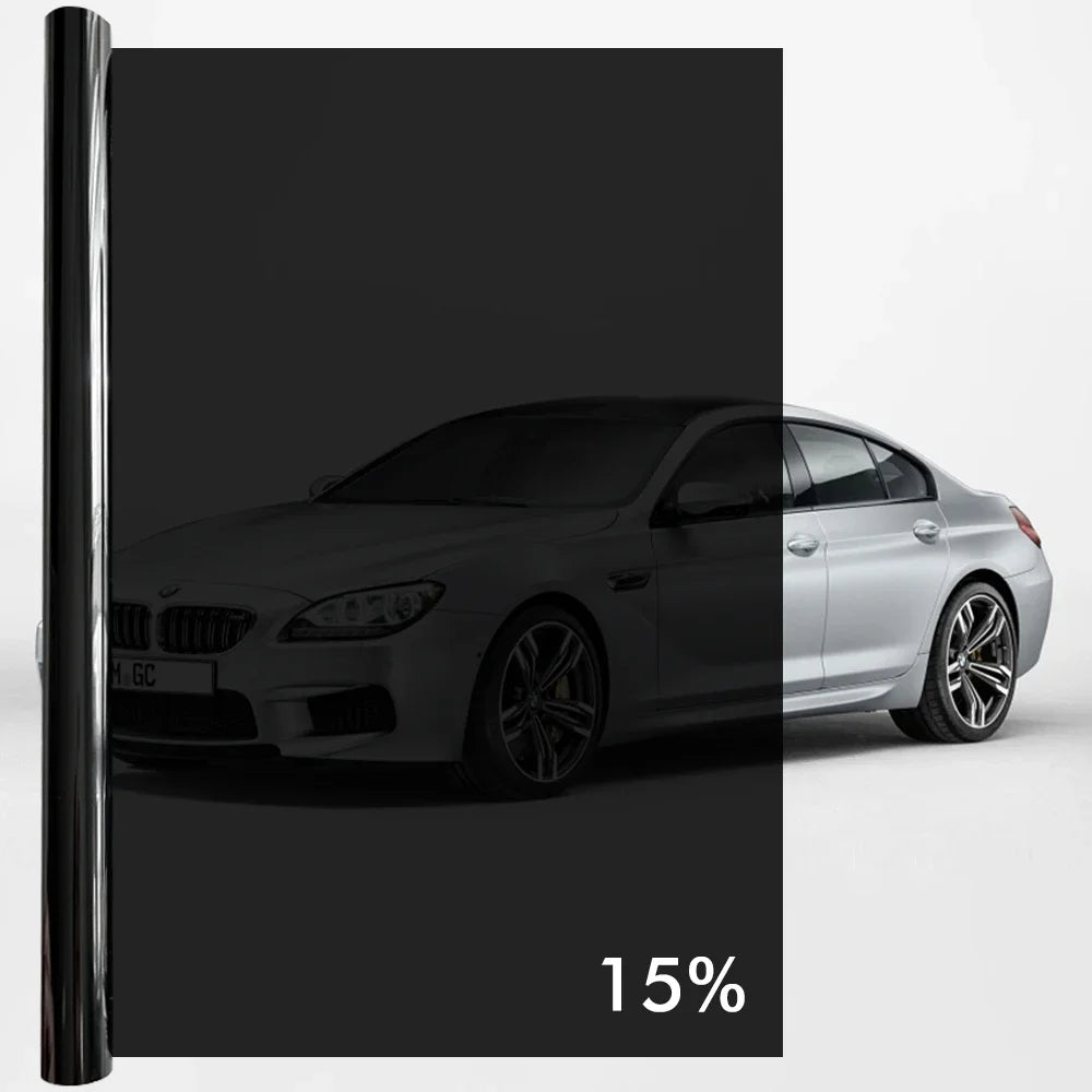 A silver BMW sedan with a black window privacy film installed, shown in a studio setting.