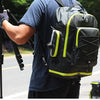 A person wearing a blue shirt carries a black and neon yellow 3-in-1 mountain bike trunk bag set on a bicycle.