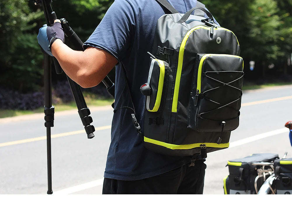 A person wearing a blue shirt carries a black and neon yellow 3-in-1 mountain bike trunk bag set on a bicycle.
