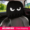 Black angry eyes car headrest covers placed on a black leather seat.