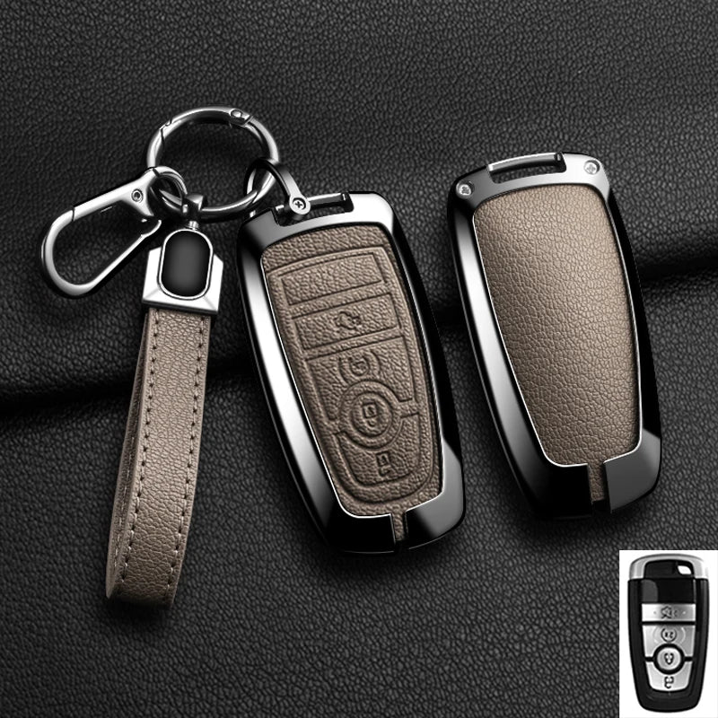 A black aluminum alloy key fob cover with a leather strap and keyring displayed on a dark surface.