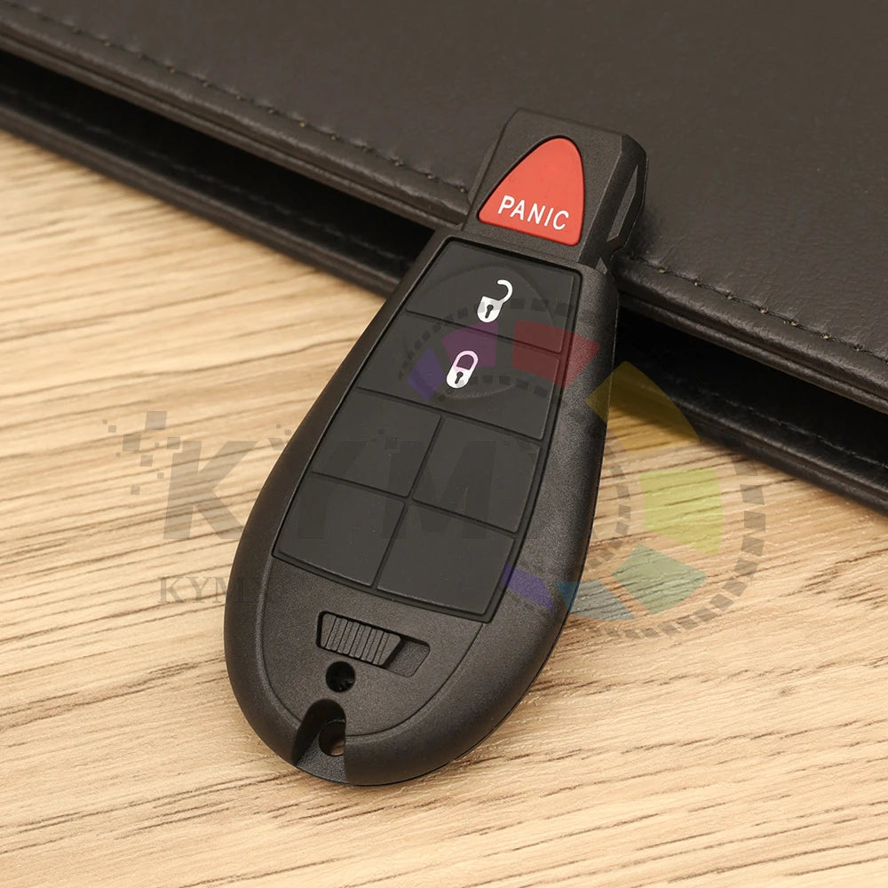 A black smart remote car key with a panic button is shown resting on a wooden surface.