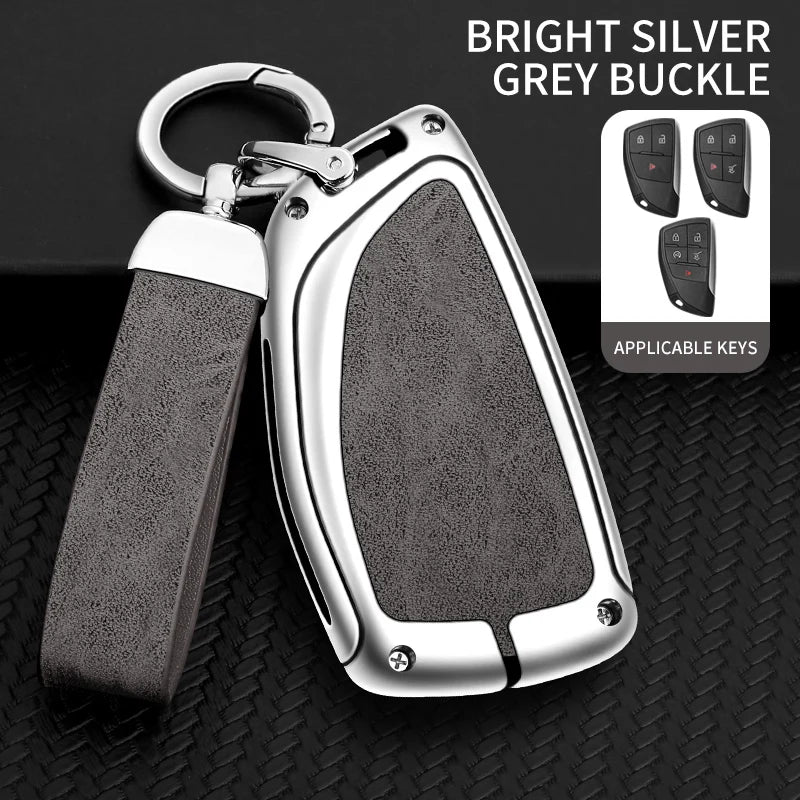 A bright silver grey buckle car key case with a lanyard and multiple keys displayed on a black textured surface.