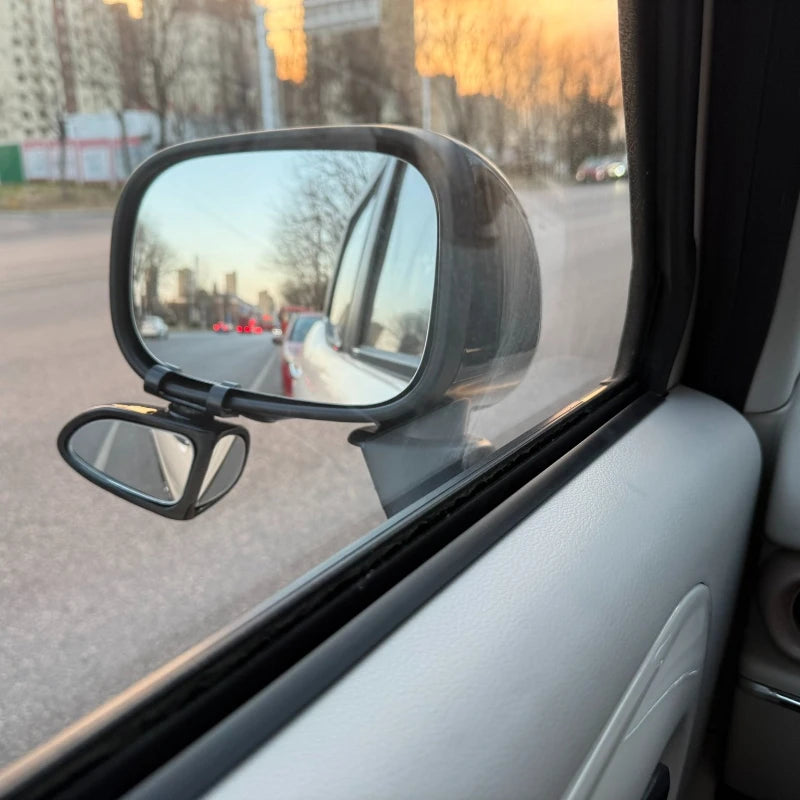 A close-up view of a vehicle's side mirror showing the road and surrounding environment.