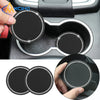 Dos posavasos de silicona negra para vasos de coche con bordes de pedrería brillante, mostrados en una mano.
