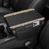 A black car console cover with a diamond grid pattern and illuminated accents resting in a luxury leather interior.