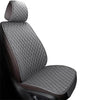 A close-up view of a dark gray quilted car seat and floor mat with brown accents.