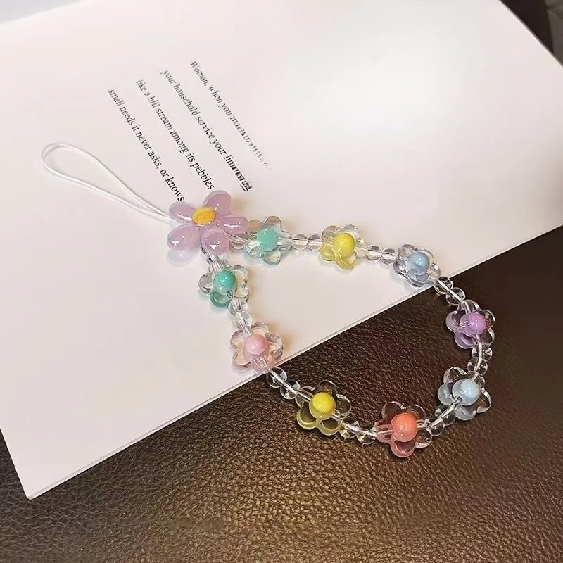 A bracelet made of round beads in various pastel colors is displayed on a white paper.