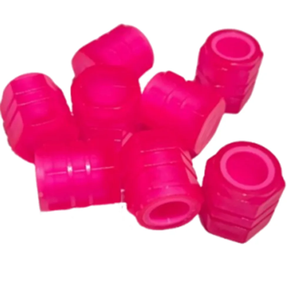 A pile of bright pink self-luminous tire valve caps.