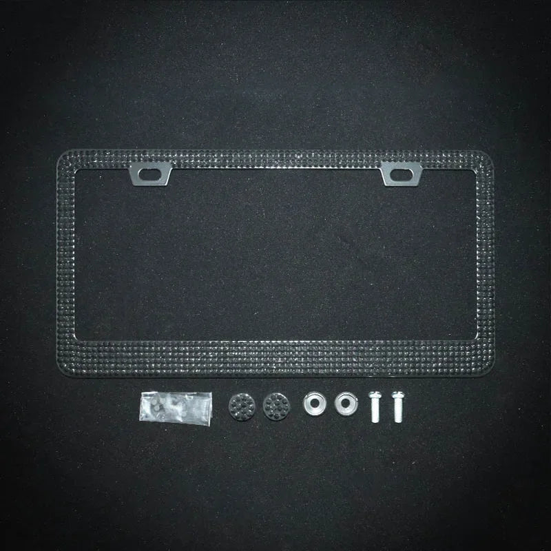 A clear crystal rhinestone license plate frame with mounting tabs and small decorative stones.