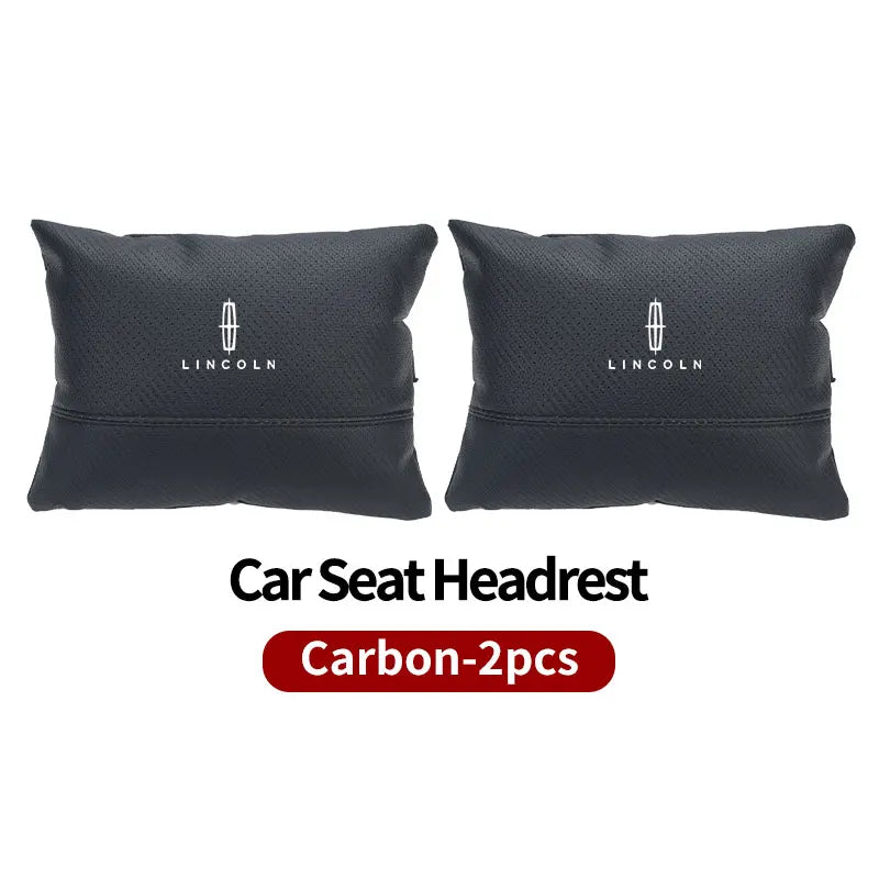 Two black Lincoln car seat headrest neck support pillows.