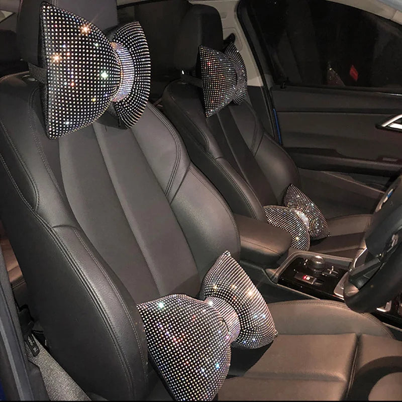 Vista cercana de un asiento de coche negro con varios cojines de cuello de pedrería de cristal.