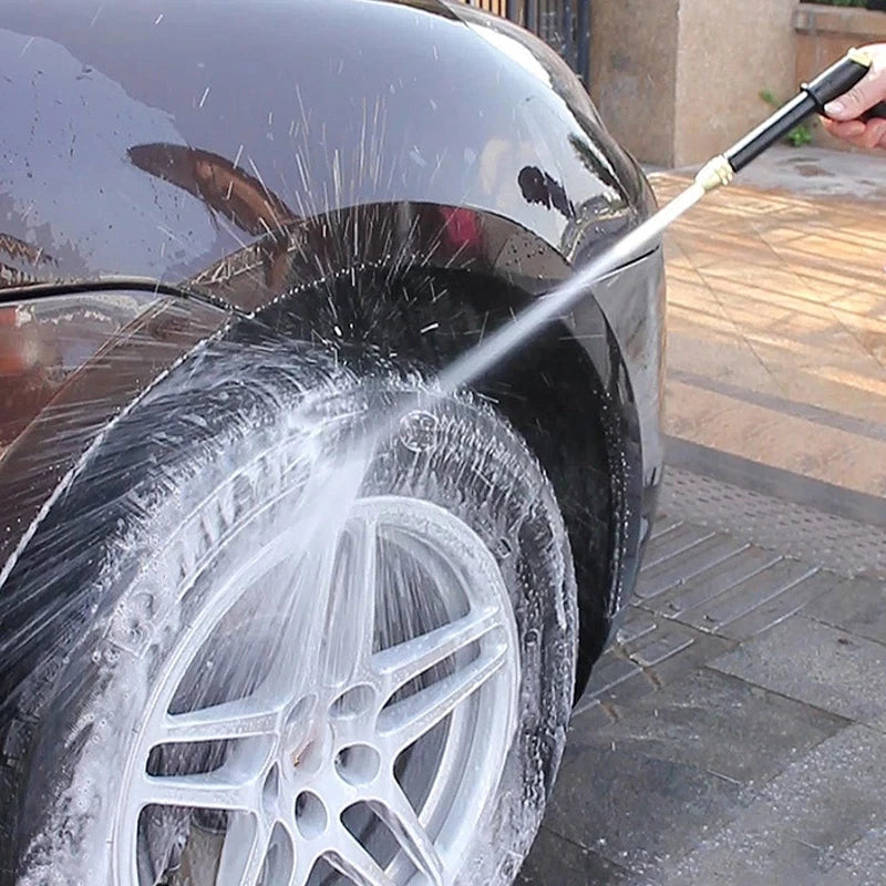 Eine Hochdruck-Wasserpistole reinigt einen Autoreifen mit einem Wasserstrahl.