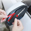 A hand is removing a black and gray rain cover for a universal car rearview mirror.