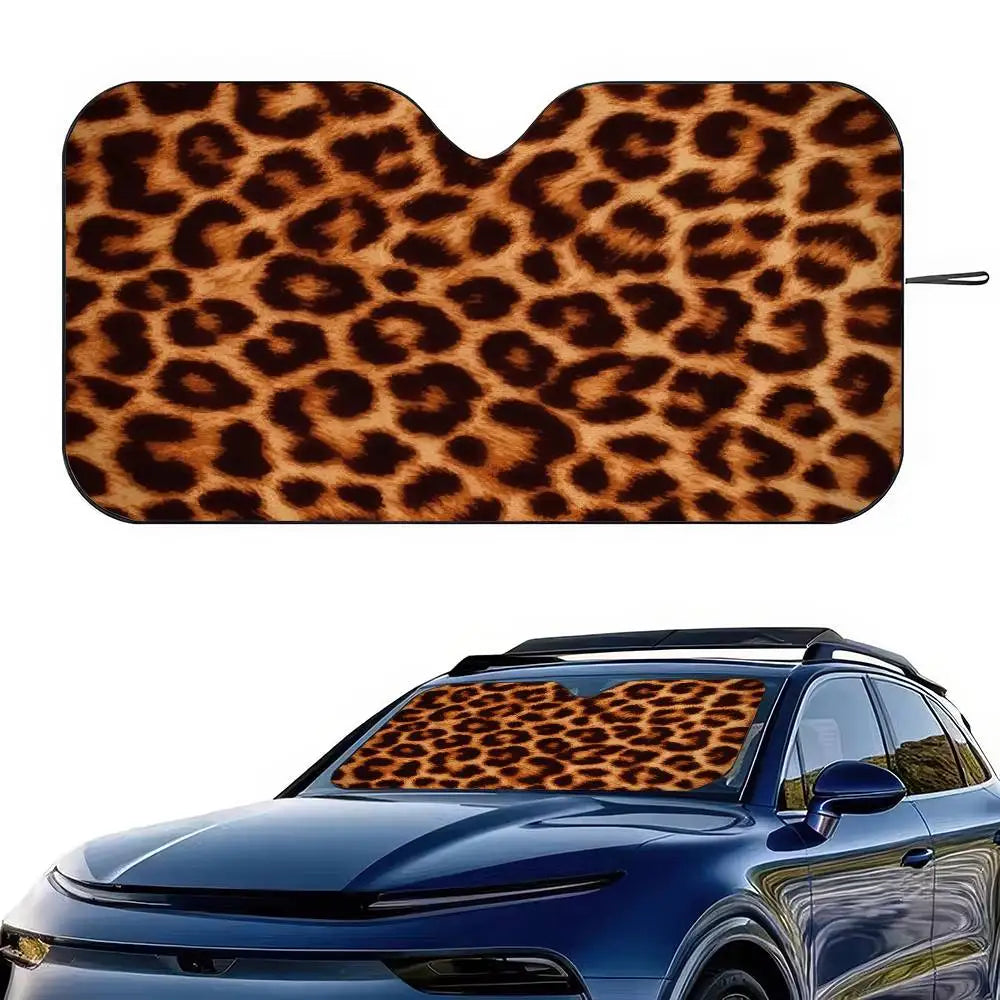 A leopard print car sunshade is shown fitted onto the windshield of a blue car.