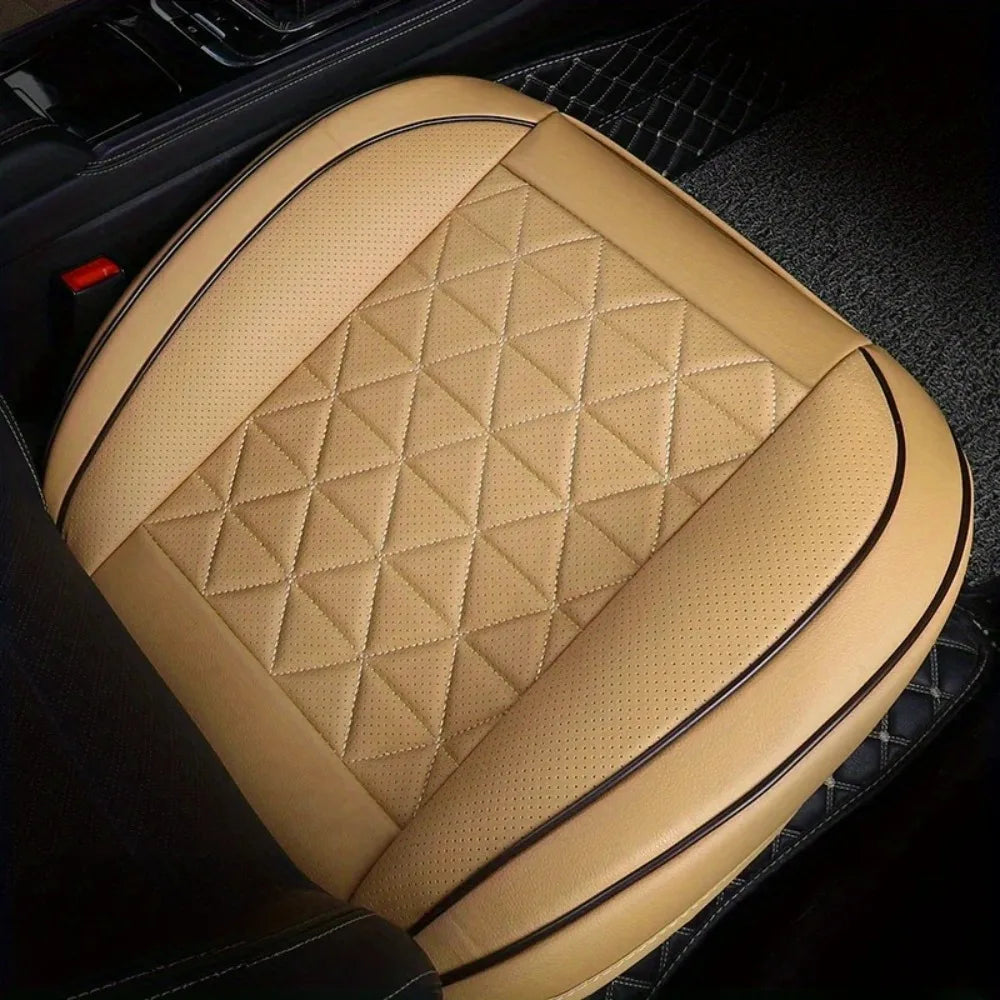 Tan quilted car front seat covers placed on a black leather interior seat.