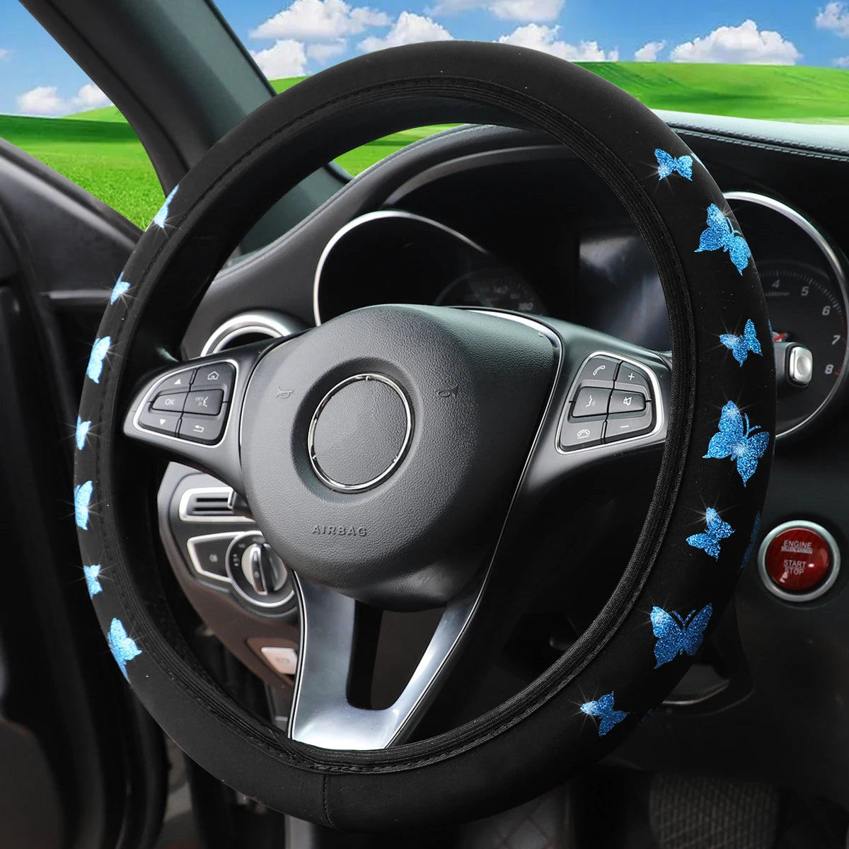 Black steering wheel with a glitter butterfly patterned cover and airbag visible inside a car