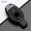 A black carbon fiber car key cover for Mercedes models shown against a dark background.