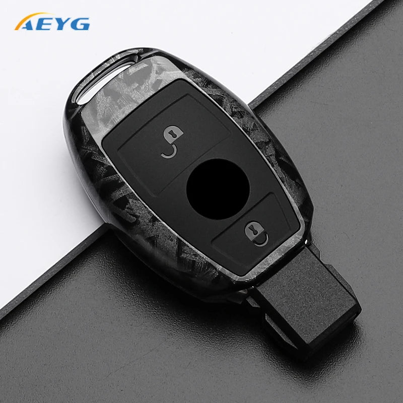 A black carbon fiber car key cover for Mercedes models shown against a dark background.