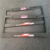 A black license plate frame decoration with HKS branding and a racing theme, shown against a gray background.