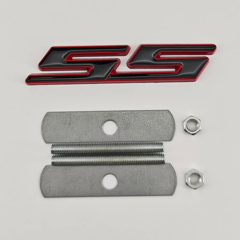 A silver metal emblem badge with a black and red SS graphic and mounting holes.