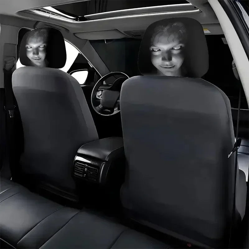 Two black universal car headrest covers with visible faces are shown in a vehicle interior.