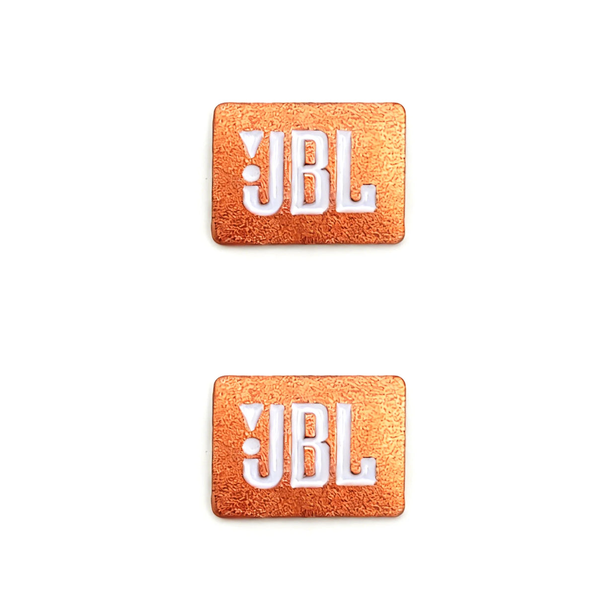 Two square, copper-colored aluminum emblems with the white letters JBL embossed on them.