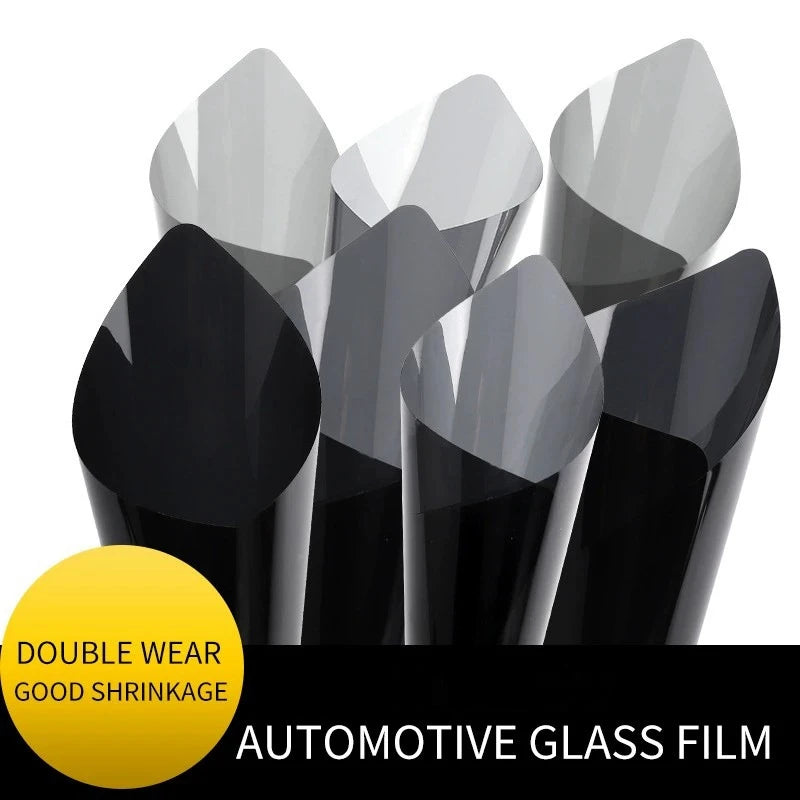 A collection of automotive glass film rolls in various shades of black and gray for tinting.