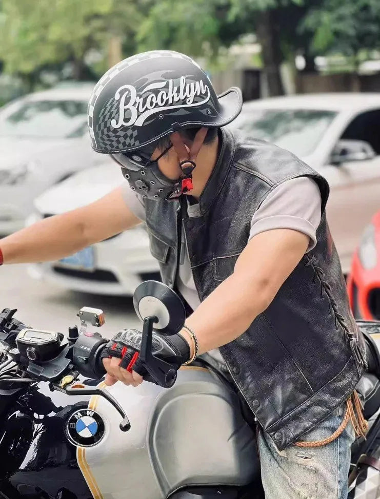 Eine Person trägt einen schwarzen Motorradhelm und fährt ein Motorrad.