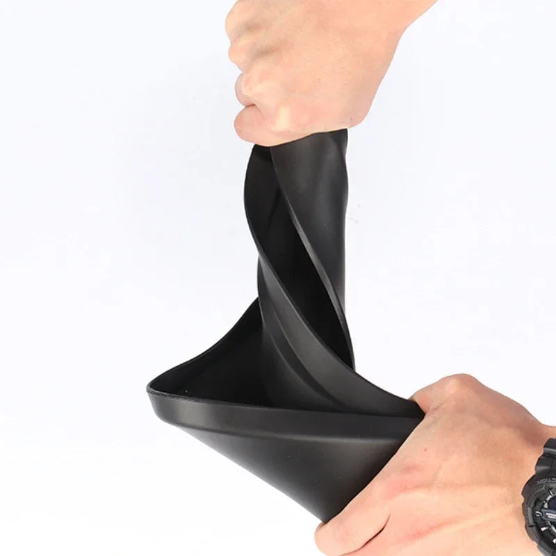 A hand is installing a black universal mud flaps set onto a car wheel.