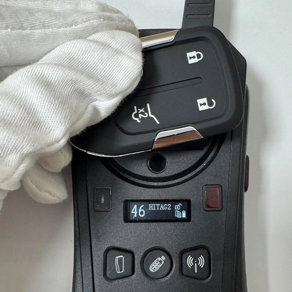 A hand wearing a white glove holds an aftermarket remote key for Chevrolet trucks and SUVs.
