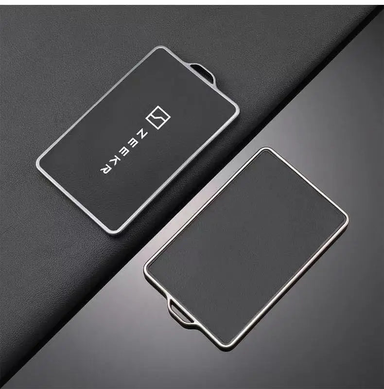 Un support de protection pour clé NFC noire repose sur une surface gris foncé.