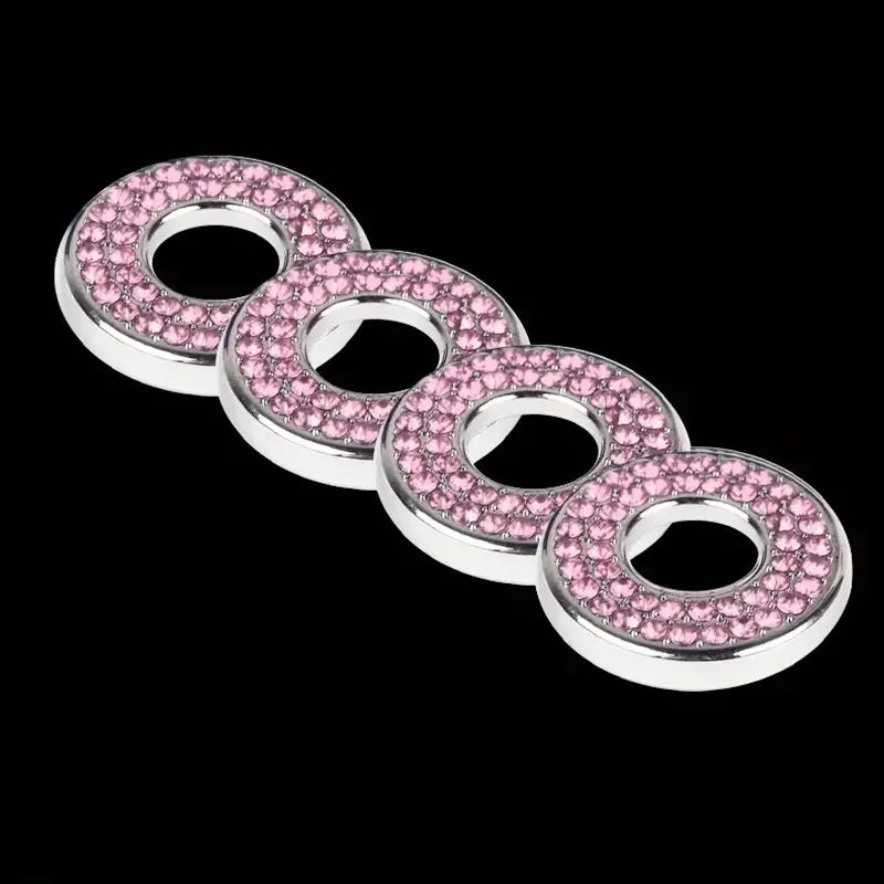 A set of pink gemstone door lock pin trim rings arranged in a row.