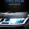 Close-up of a car headlight with blue tint film applied, showing the protective coating on the lens.