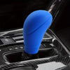 A blue gear shift knob and handbrake cover set is shown mounted in a car's interior console.