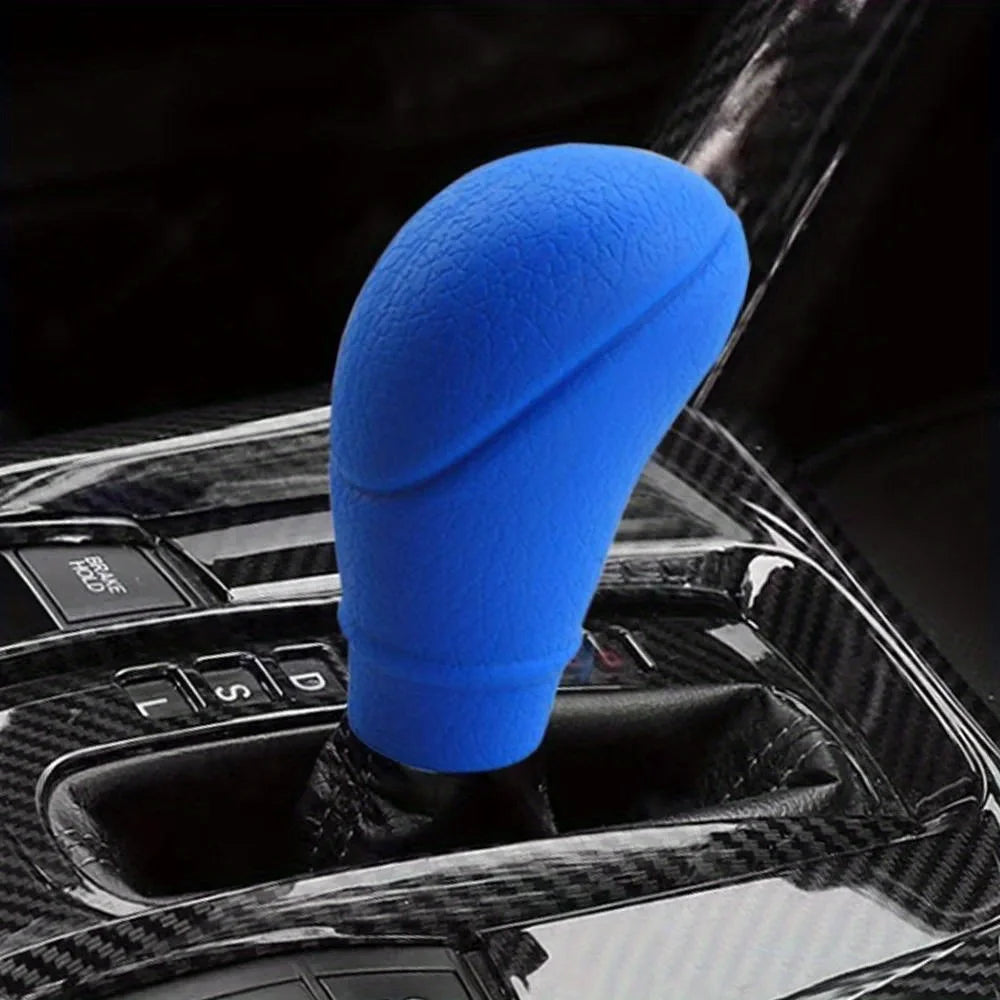 A blue gear shift knob and handbrake cover set is shown mounted in a car's interior console.
