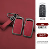 A set of red leather key cases and a car key fob displayed on a maroon background.