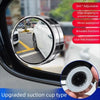 A close-up view of a 360 degree adjustable blind spot mirror installed in a car window.